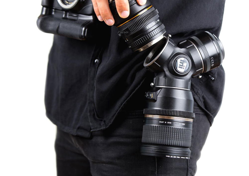 A person holding a camera lens with different lenses attached to it.