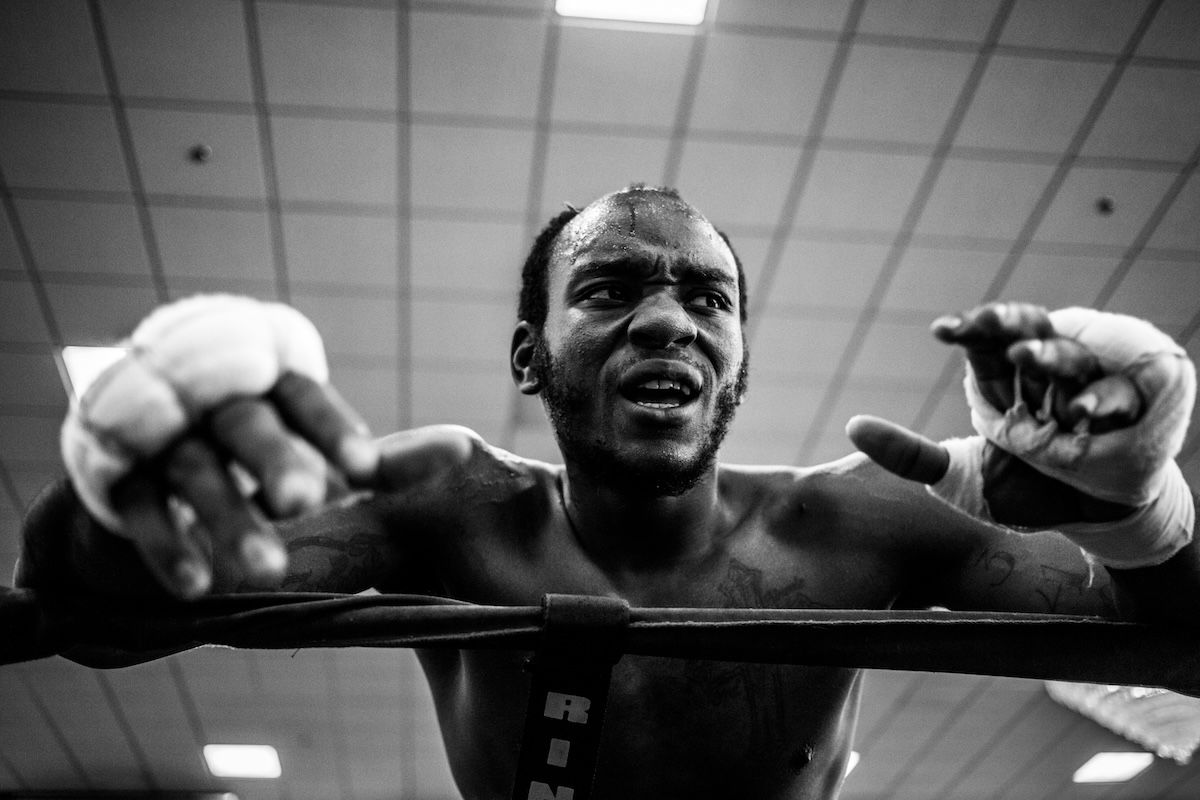 A tired boxer leaning on ropes as an example of boxing photography