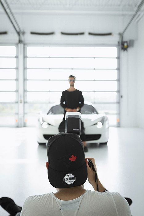 A photographer shooting an indoor portrait with a dslr camera with a flash diffuser attached