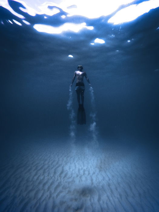 an underwater portrait of a diver with subtle vignette on the image