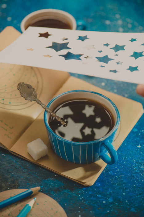 a creative still life featuring star shaped reflections in a coffee cup