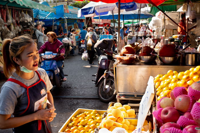 studio portrait of a female vendor in a busy market shot using fill light sources