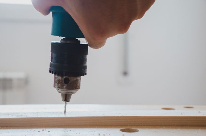 a person making a DIY wood backdrop for photography