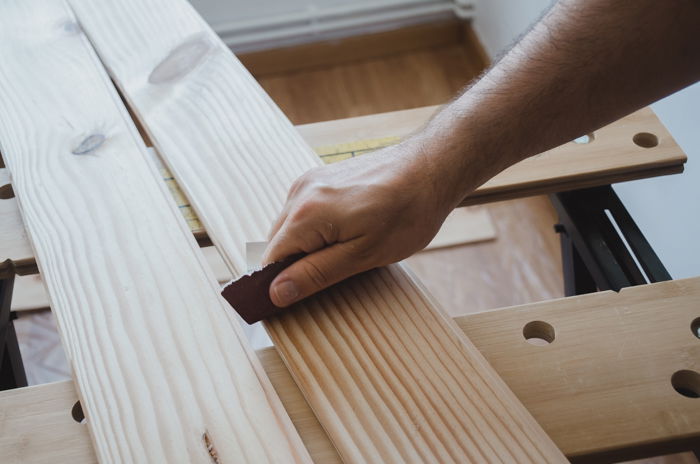 a person making a DIY wood backdrop for photography