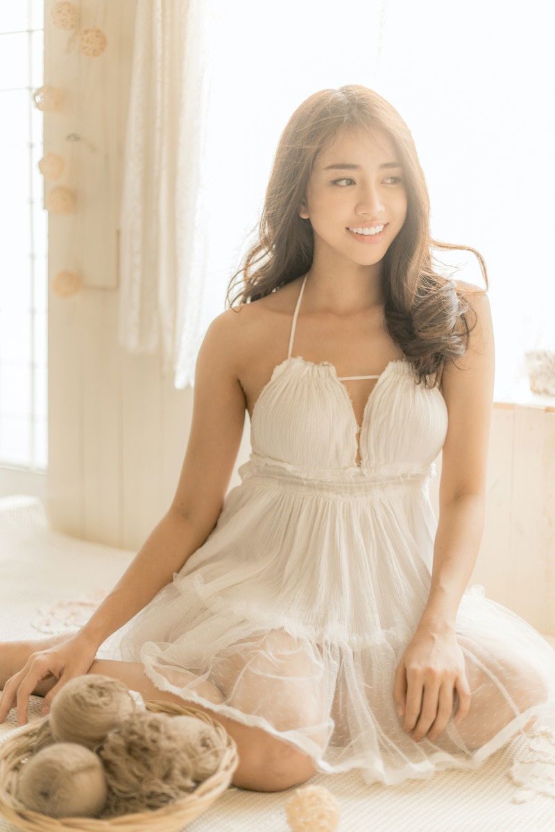 Woman posing in lingerie by a window for a boudoir shoot