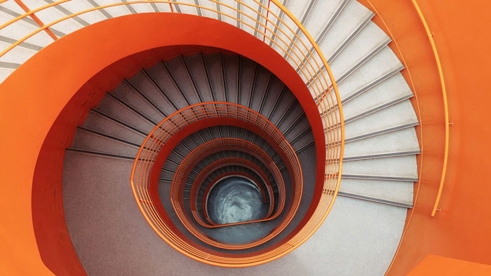 overhead shot of a winding orange staircase - symbolism in photography