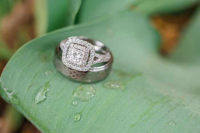 wedding rings resting on a rain covered leaf