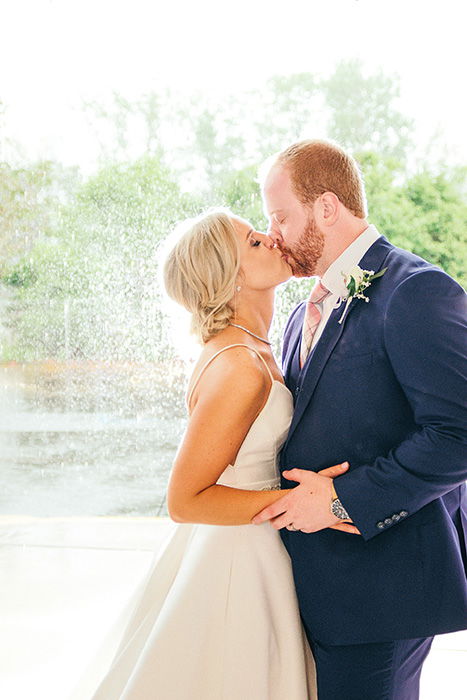 portrait of the newlyweds kissing at an outdoor wedding photography shoot