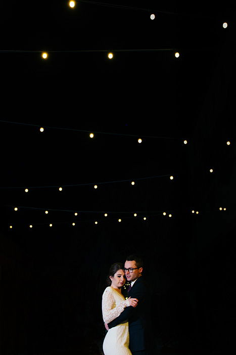 portrait of the newlyweds dancing at an outdoor wedding at night