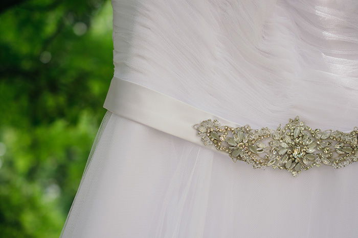 a close up of details of a wedding dress at an outdoor wedding photography shoot 