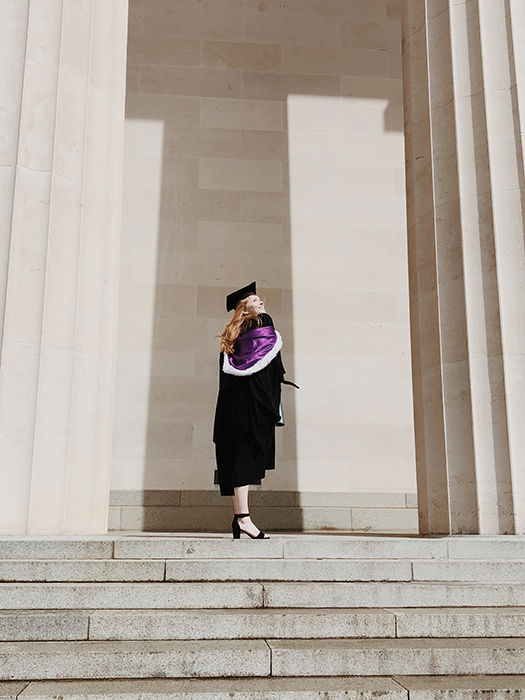 a graduate from a photography school standing outside the university 