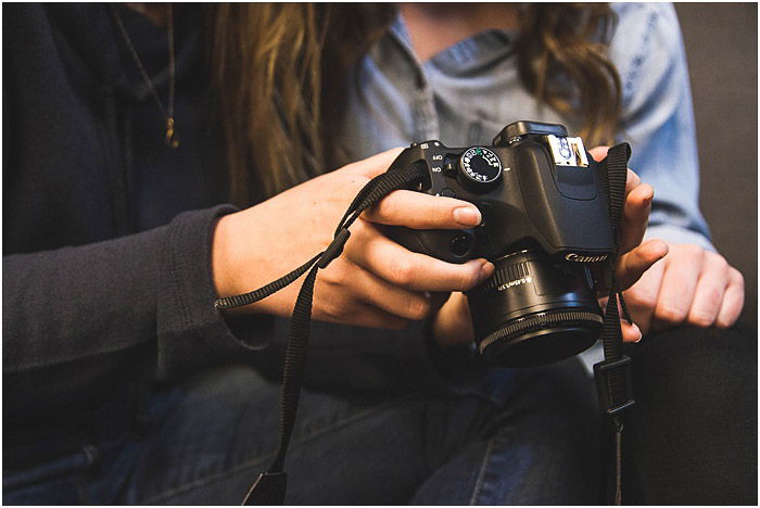 potrrait photographer reviewing images on a DSLR