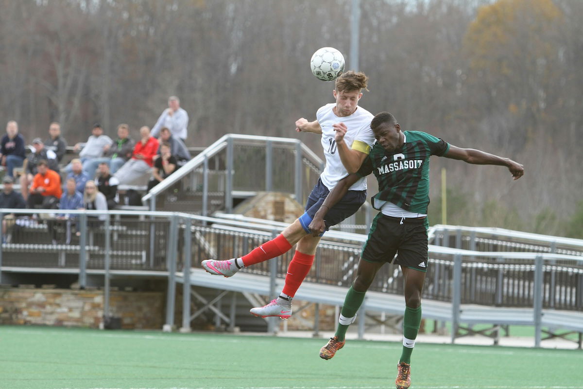 Two players jostling midair to head a ball as an example of soccer photography