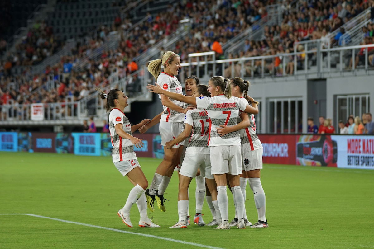 Players celebrating in a huddle as an example of soccer photography