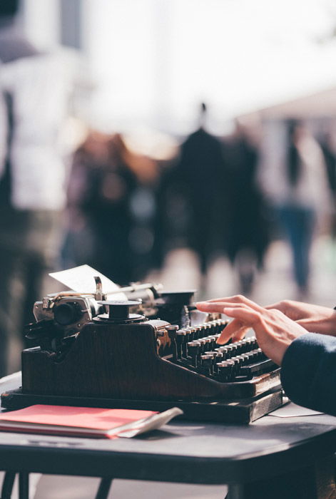 a person typing on a vintage typewriter - symbolism in photography