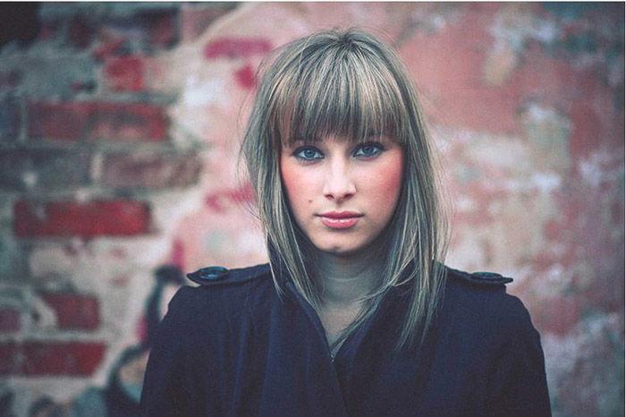 Portrait of a girl in front of a brick wall grainy matte portrait preset