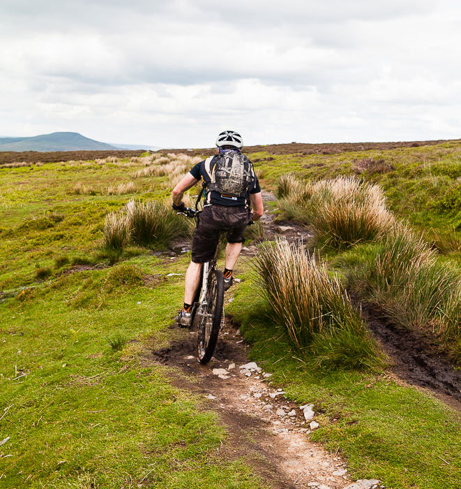 A freeze motion photography shot of a cyclist biking through a countryside path