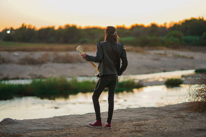 Photo of a man starting with a guitar with her back to the camera