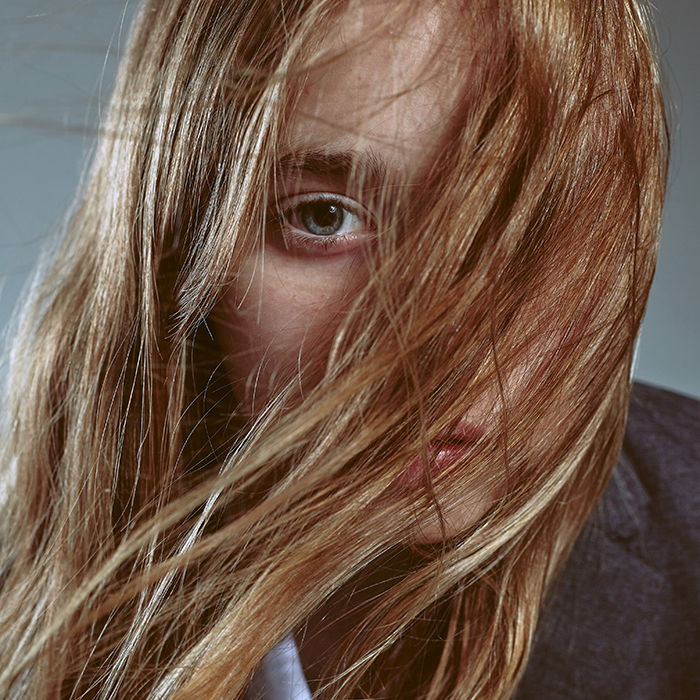 close-up portrait photography of a woman with her hair in her face