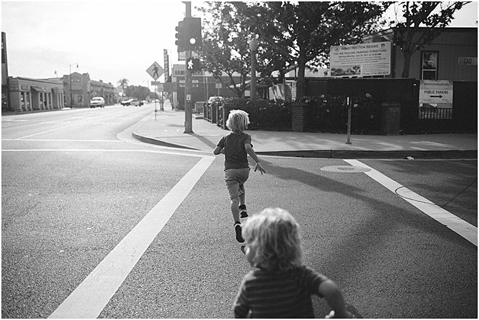 Black and white photo of children running on the street