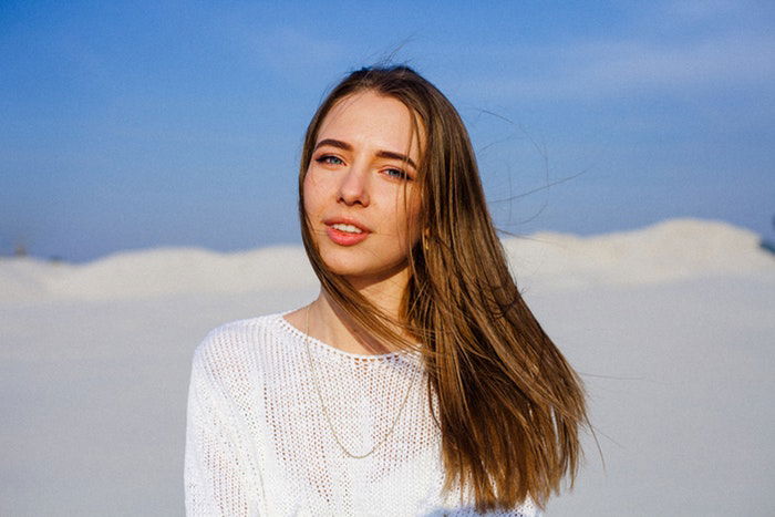 A portrait photo of a woman wearing a white jumper