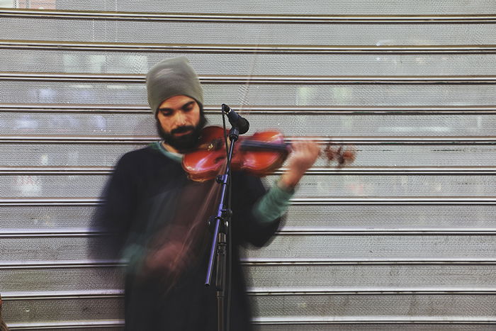 Motion blur photo of a man playing the violin