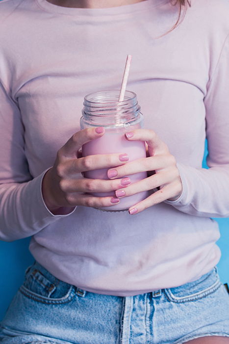 cool nail photography of a female model with pink painted nails