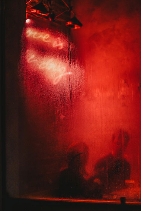 Photo of a bar with red light reflecting on the window