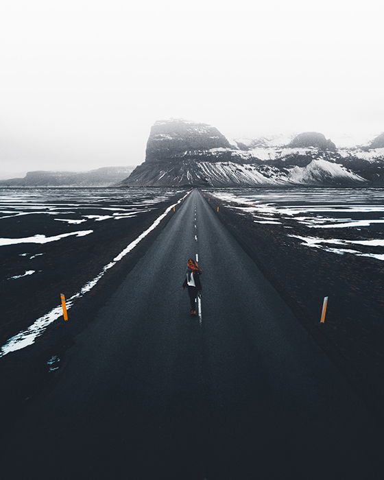 Photo of a long road and snowy mountains in soft light