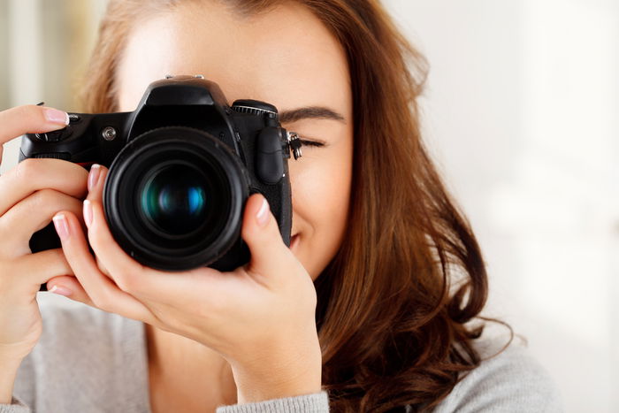 Close-up of a woman holding a camera to take a picture