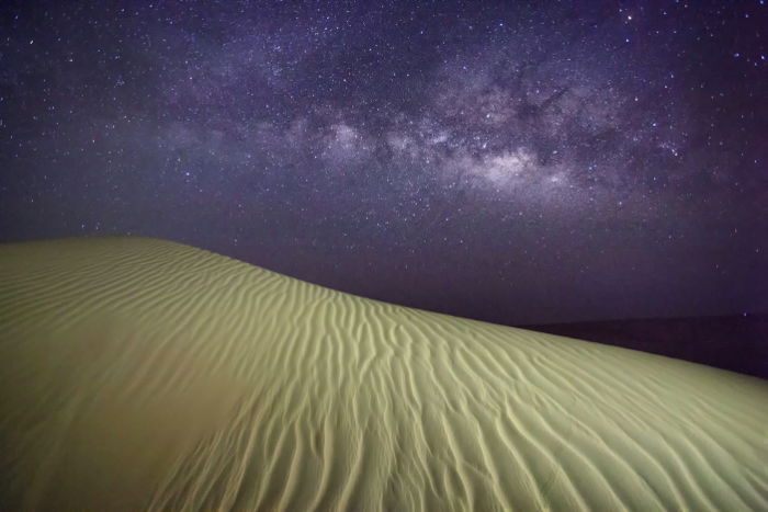 The Milky way over a sand dune shot with a full frame camera