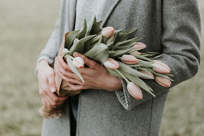 a close up of a person holding flowers at a funeral 