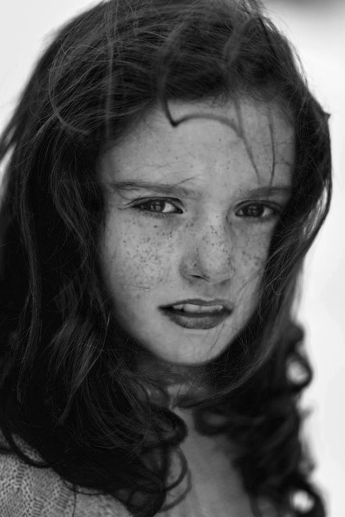 Black and white portrait photo of a girl with freckles