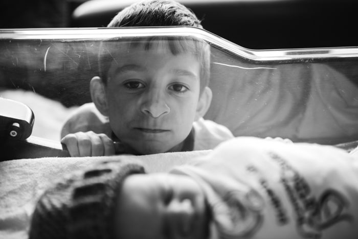 Photo a child watching his brother sleeping in a crib