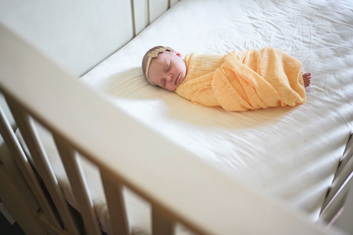 Photo of a baby sleeping in a yellow blanket