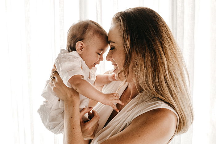 a sweet mommy and me photoshoot of a mother holding her baby