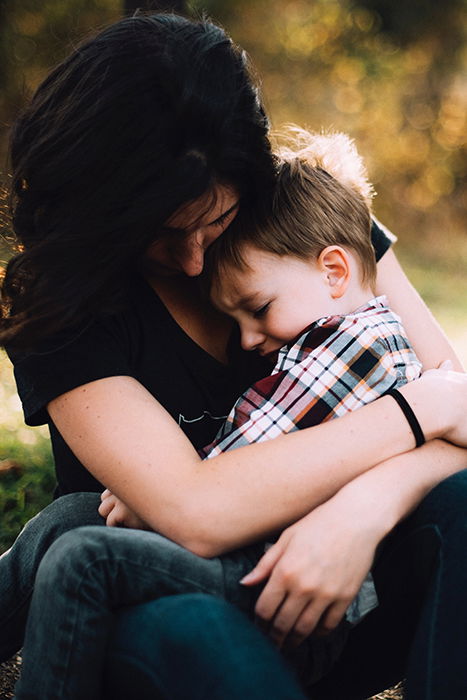 a sweet mommy and me photoshoot of a mother holding her young outdoors