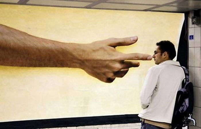 Photo of a guy standing in front of a billboard 