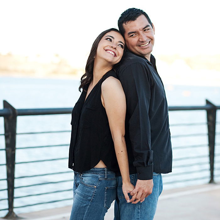 a romantic portrait of a couple trying back to back engagement photo poses outdoors