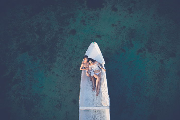 Drone wedding photo with the couple in a boat on the sea