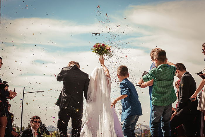 Wedding photo of the married couple and flower petals in the air