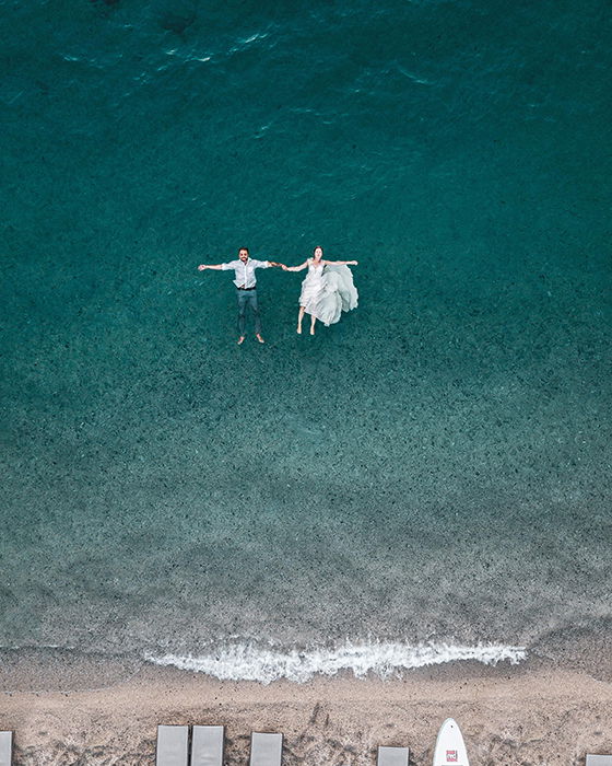 Drone wedding photo with the couple floating on the sea