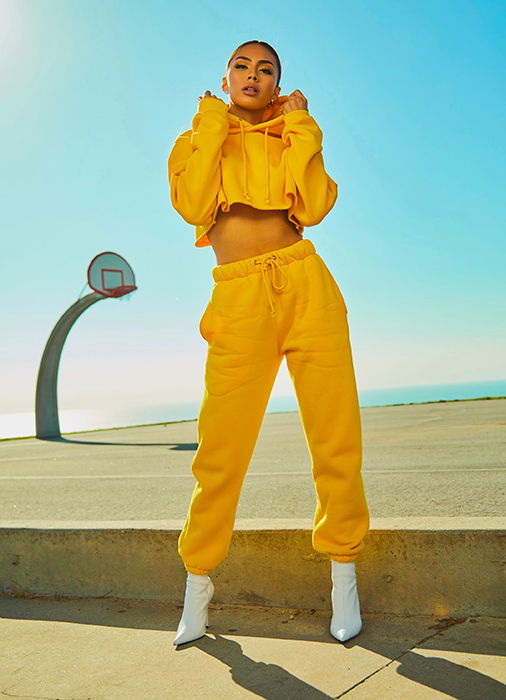 Photo of a model in a wellow tracksuit on the beach