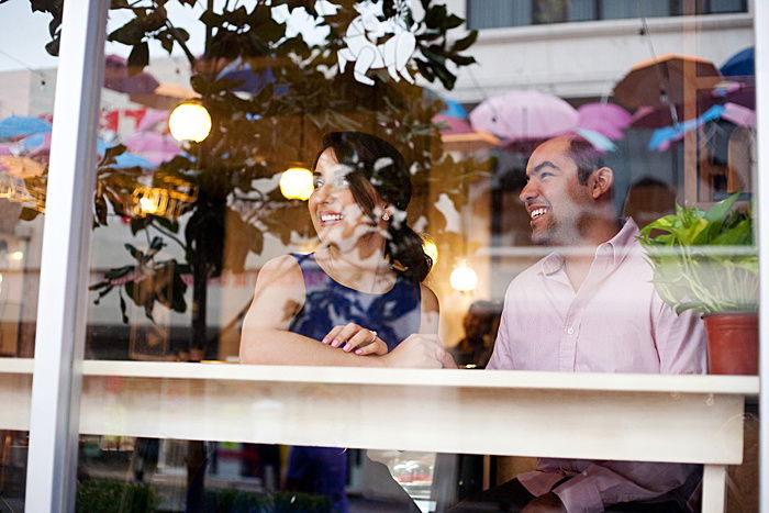 a couple smiling at a cafe window