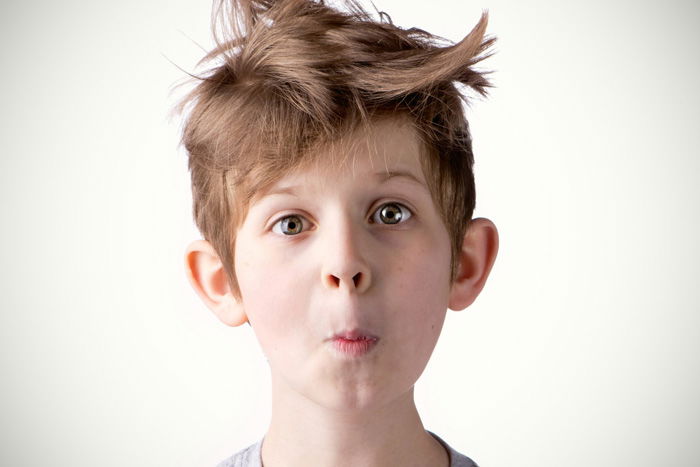 a portrait of a little boy with messy hair