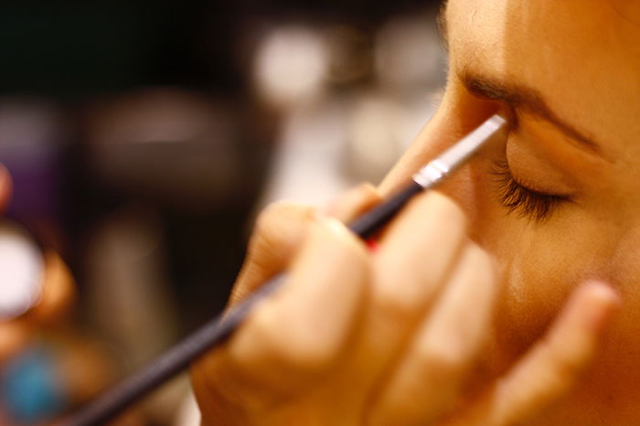 Photo of a hand applying eyeshadow on a model