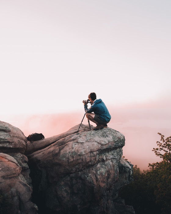 A photographer taking a photo on a cliff