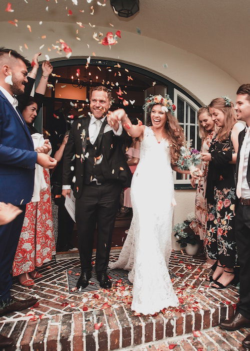 A shot of a bride and groom leaving the ceremony, with confetti in the air 