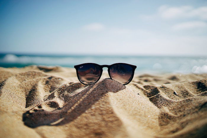 Photo of sunglasses shot on the beach in the sand