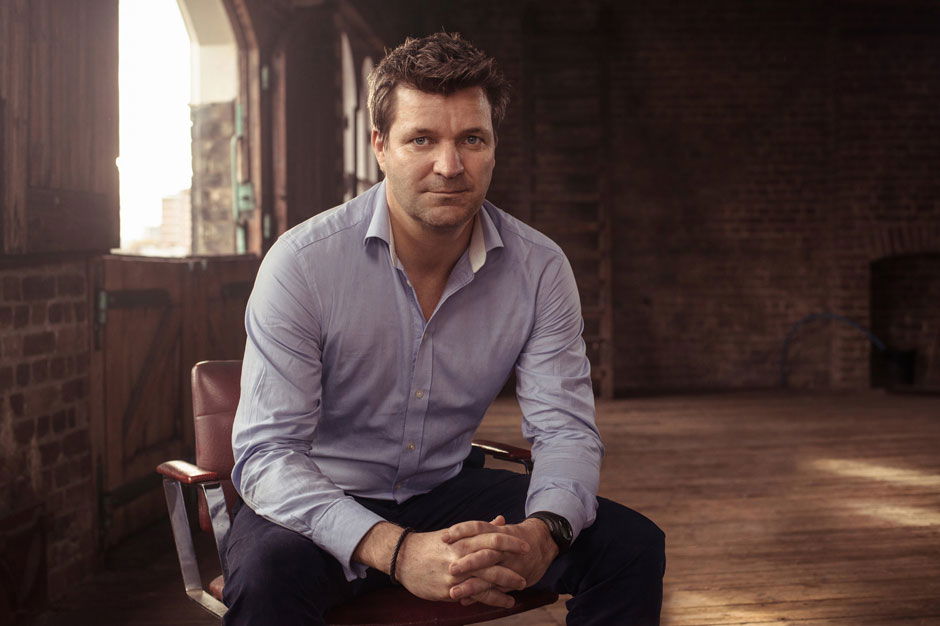 A man sitting in a chair indoors shot with loop portrait lighting